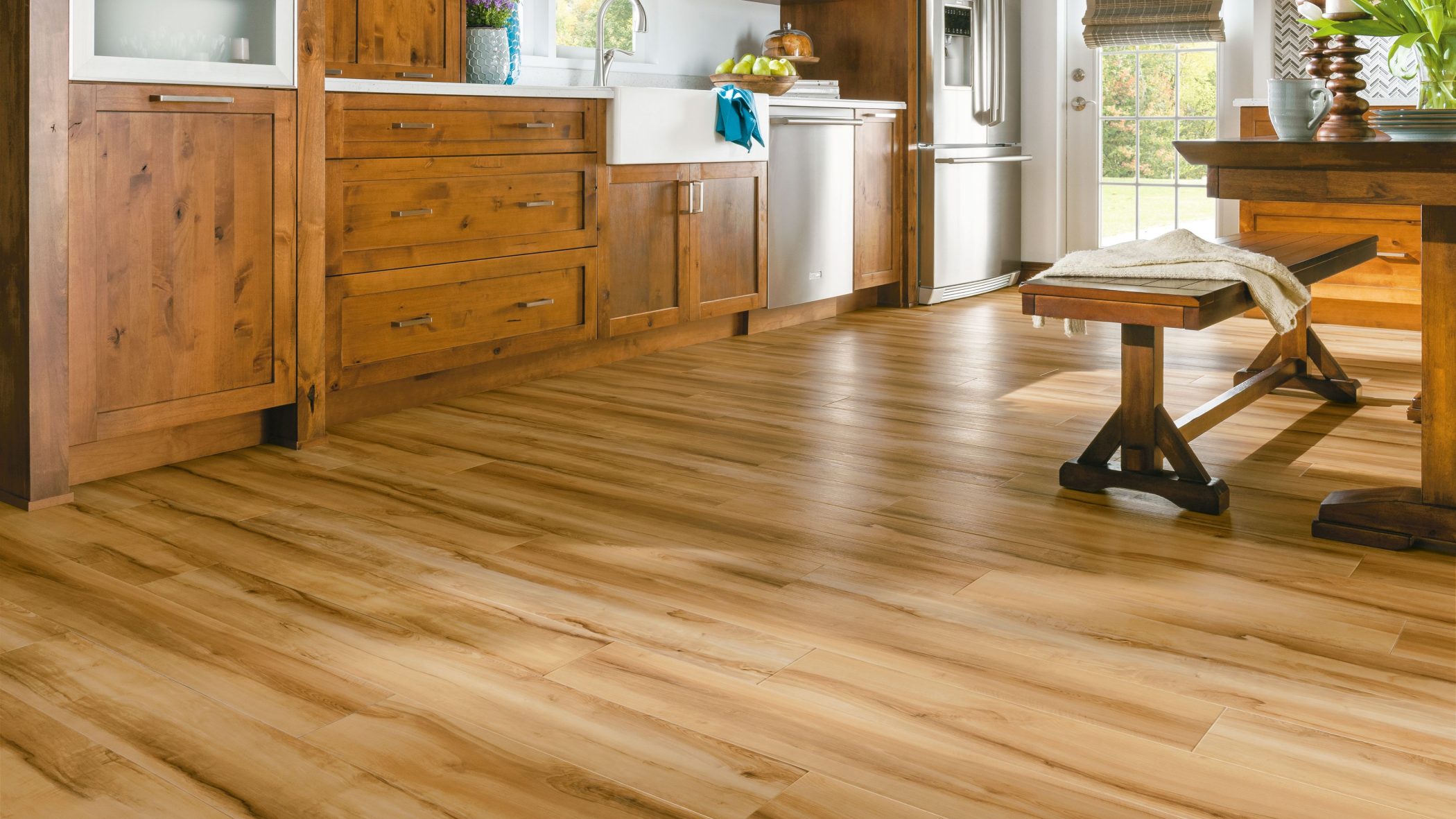 gallery-03 A kitchen with warm, honey-colored wood cabinets and a matching wood-plank floor.